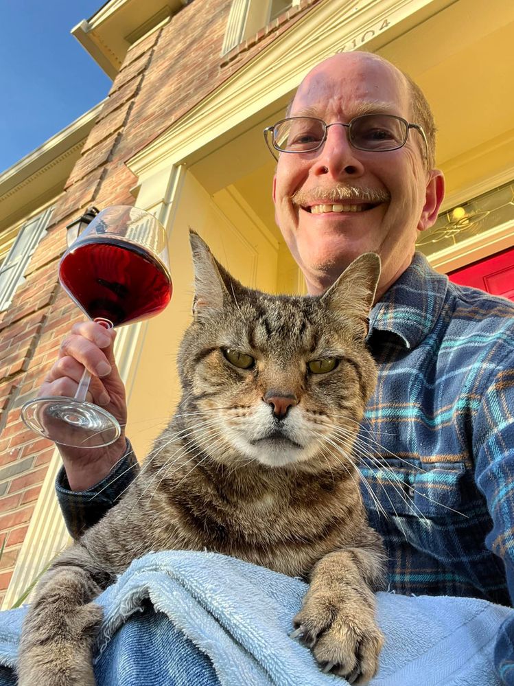 Brushing Tiger on my lap (with a towel to protect my legs from his claws).  Yes, I enjoy wine.