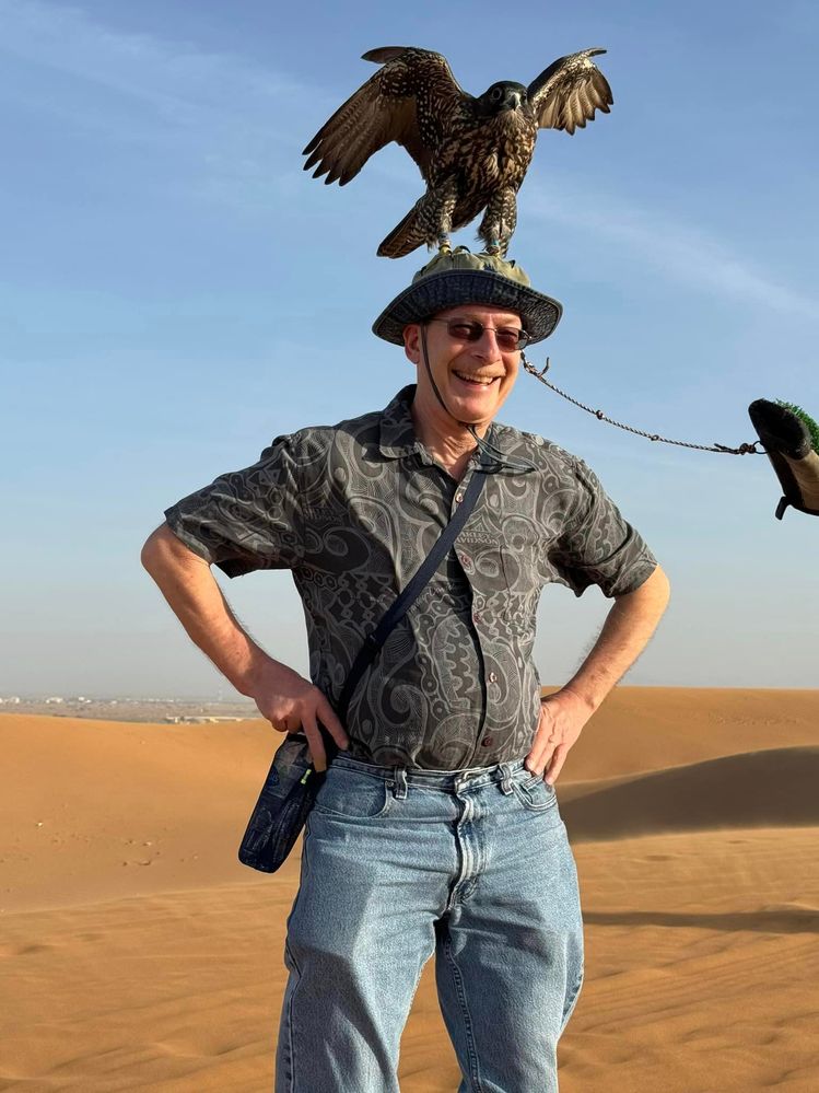 That's a falcon on my head.  We rode in Toyota Land Cruisers in the dunes of Abu Dhabi.